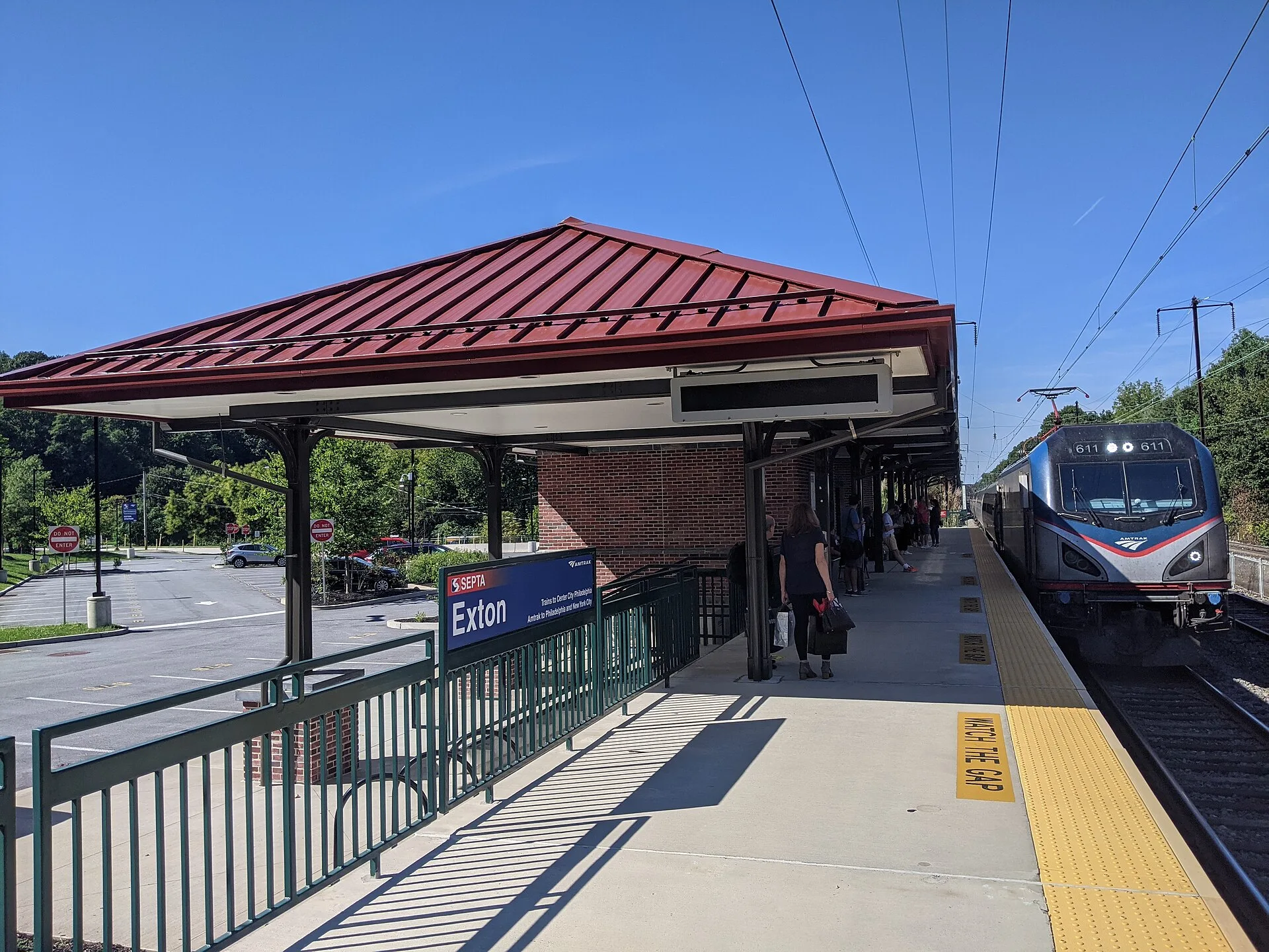 Amtrak Keystone Service train 664 arrives at the Exton, Pennsylvania, USA station. Image includes main station building, high-level platform, train, and passengers waiting to board. Amtrak weekend travel costs explained line by line