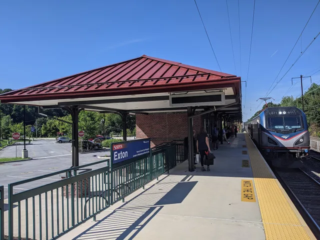Amtrak Keystone Service train 664 arrives at the Exton, Pennsylvania, USA station. Image includes main station building, high-level platform, train, and passengers waiting to board. Amtrak weekend travel costs explained line by line