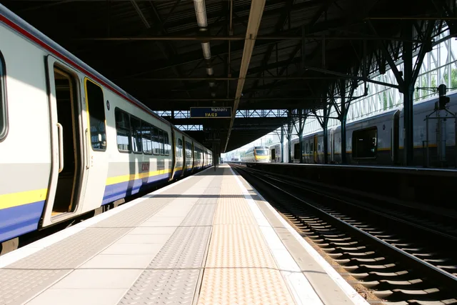 Train stopped at a station platform with open carriage doors. Walkable business districts can do a lot for visitors who arrive car-free